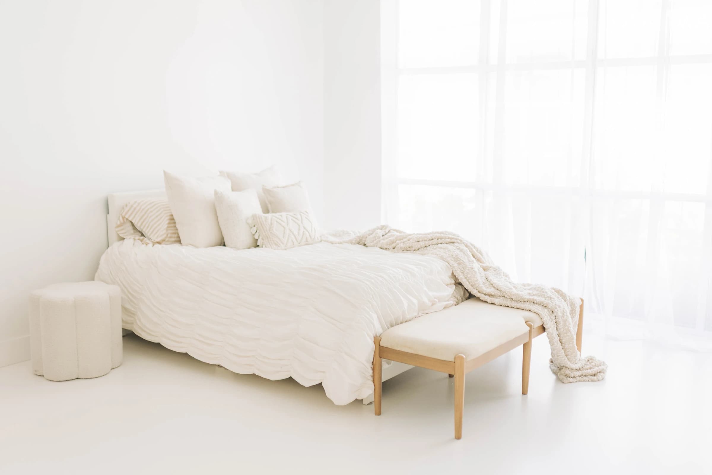Window light falling across the full-size bed in Studio A