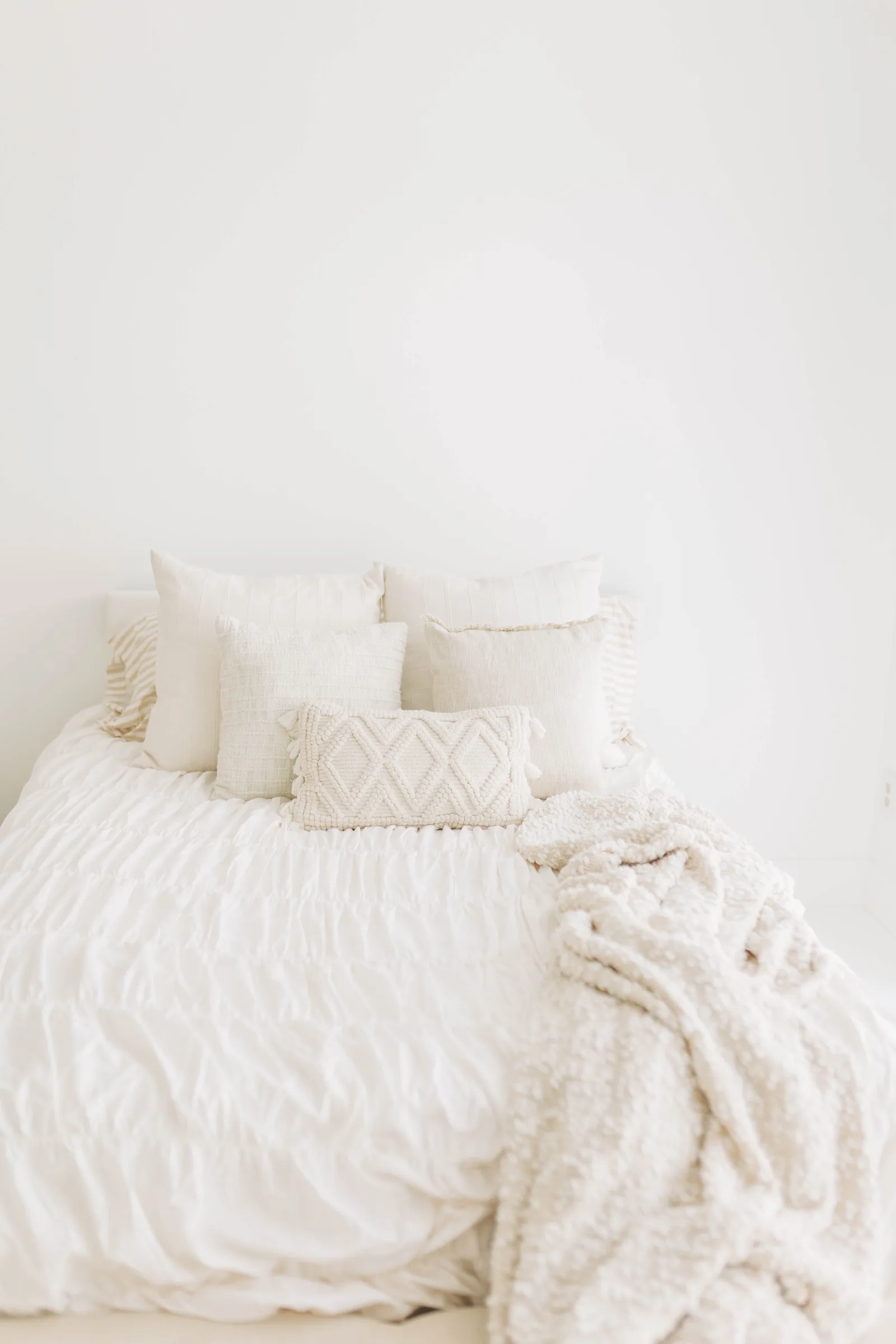 A warm, naturally-lit room with a comfortable styled bed, ideal for maternity portraits