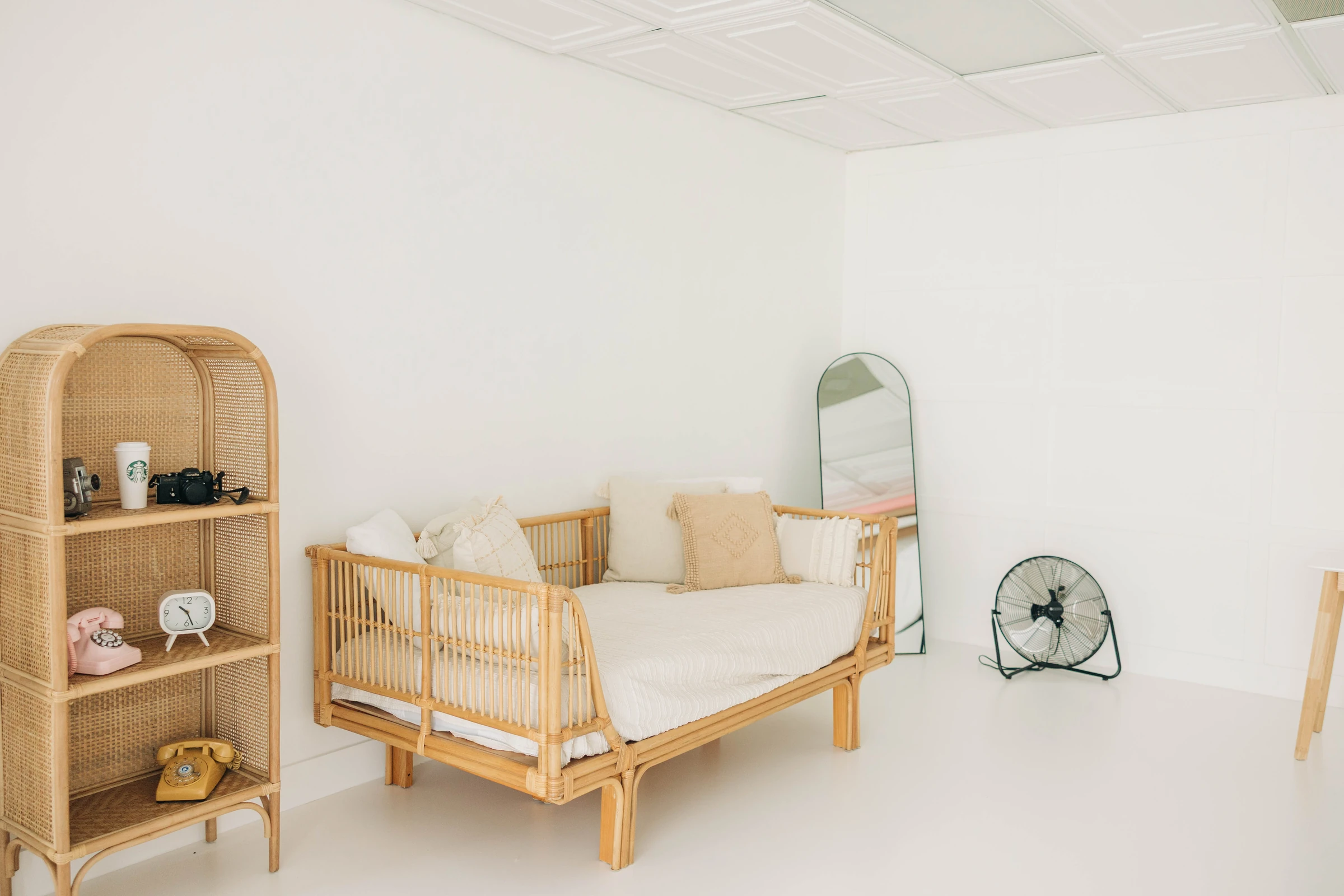 The rattan daybed and styled prop shelf in Studio A's soft light