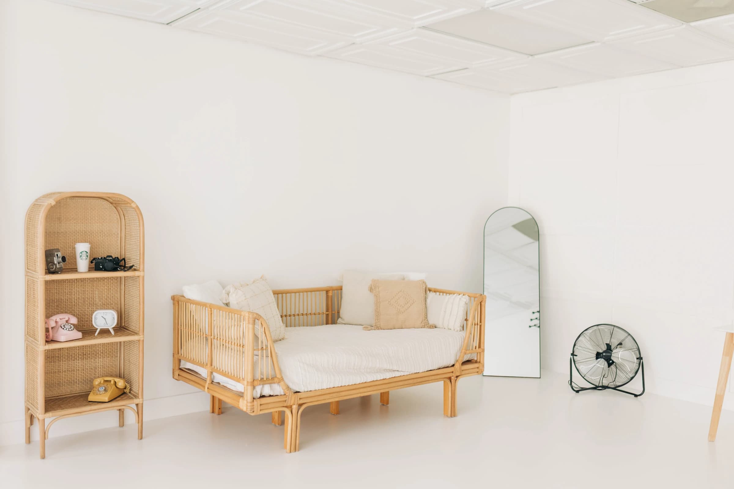 Studio A's rattan daybed and arched shelf