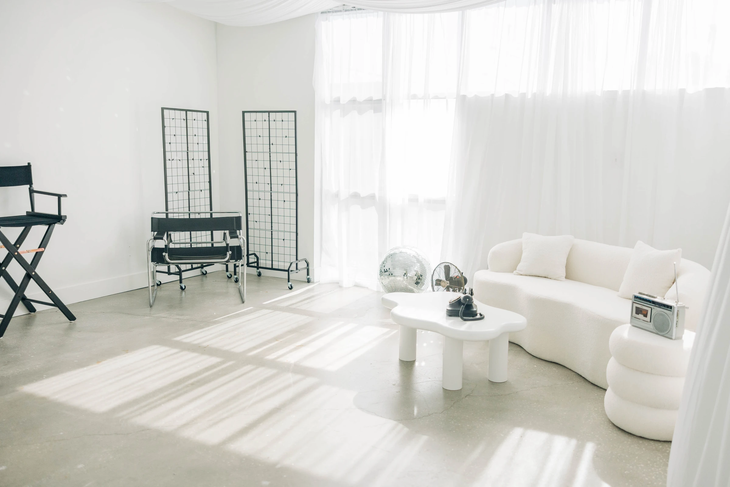 Studio B's curved white sofa and grid panels in bright daylight