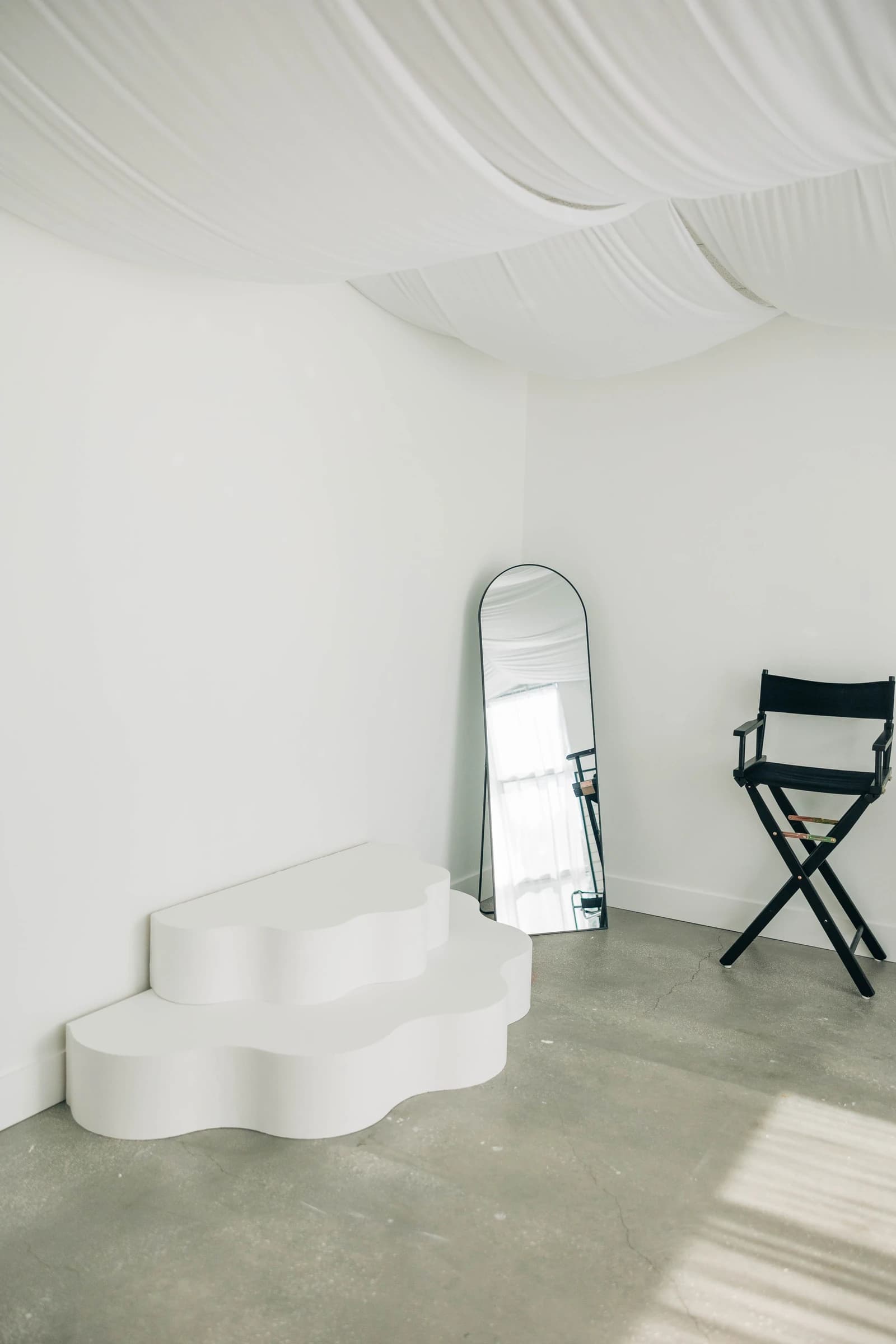 The wavy white stage and a director's chair in Studio B