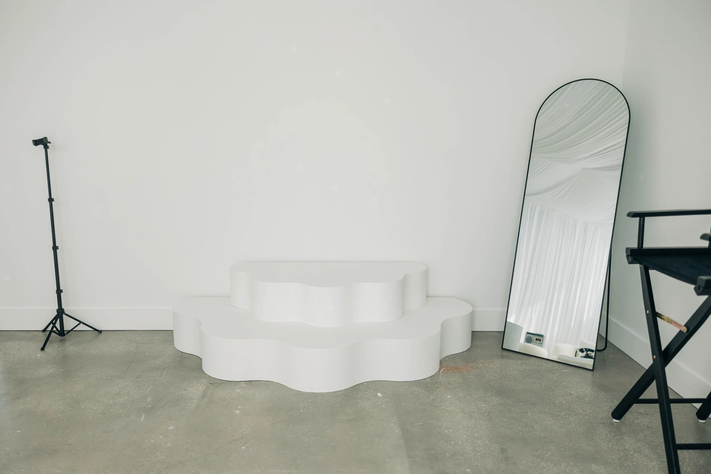 The wavy white two-tier stage on Studio B's concrete floor